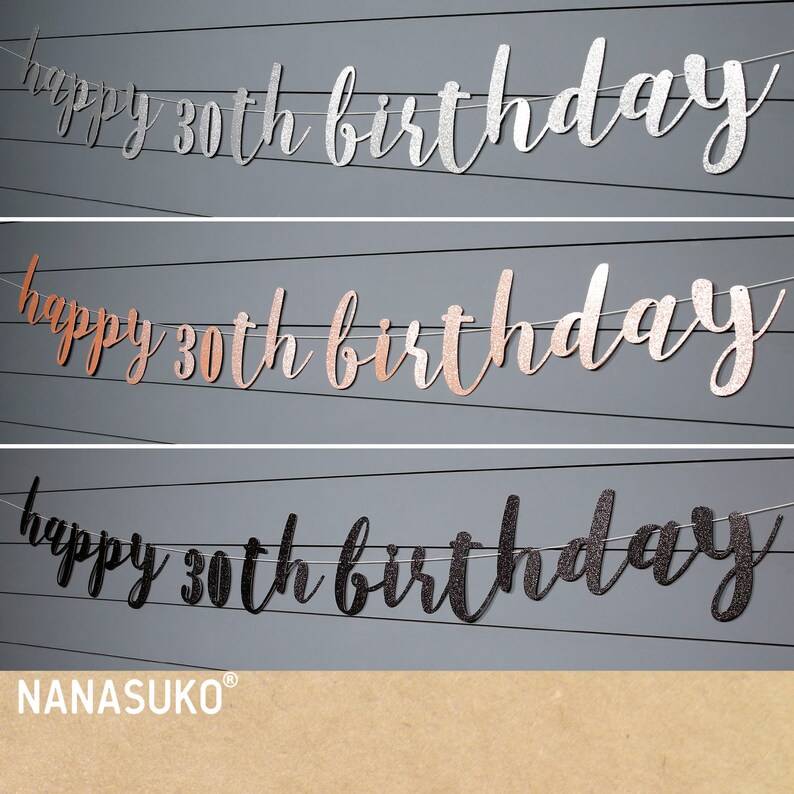 May include: Three happy 30th birthday banners in silver, rose gold, and black glitter. The banners are strung on white string and are hanging against a gray background. The text "NANASUKO&reg;" is printed in the bottom right corner.