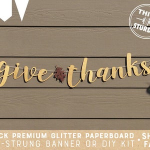 May include: A gold glitter paperboard banner with the words "give thanks" and fall leaves. The banner is pre-strung and comes with a thick, sturdy construction.