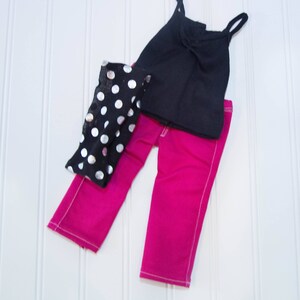 May include: A black tank top, pink pants, and a black and silver polka dot scarf. The outfit is for a doll.