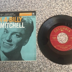 May include: A vintage 45 RPM record by Guy Mitchell titled "Rock-A-Billy" with a Columbia Records label. The record cover features a black and white photo of Guy Mitchell.