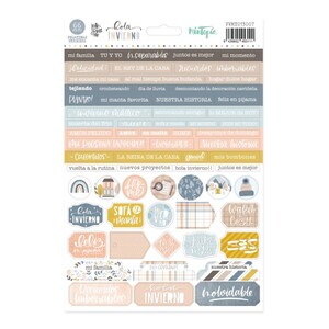 May include: A sheet of colorful stickers with winter-themed illustrations and Spanish text. The stickers feature images of snowflakes, houses, fireplaces, and other wintery scenes. The text includes phrases like "Hola Invierno" and "Nuestra Historia".
