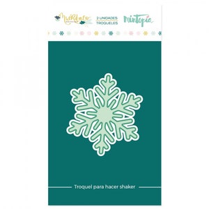 May include: A green snowflake die cut for making shaker cards. The die cut is on a teal background with the text "Muerda Co. 2 unidades Troqueles Mintopia Troquel para hacer shaker" in white.