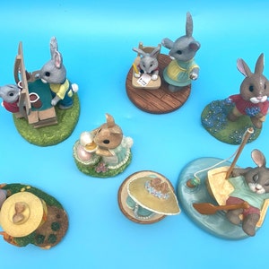 Puede incluir: Un conjunto de 8 figuritas de conejo de cer&aacute;mica pintadas a mano. Cada conejo est&aacute; vestido con ropa diferente y tiene una personalidad &uacute;nica. Los conejos est&aacute;n sentados en varias bases, incluyendo una escuela, un barco y una maceta.