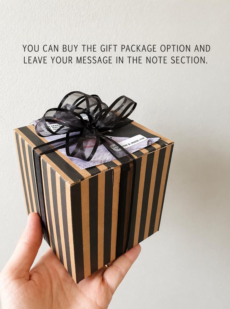 May include: A gift box with black and tan vertical stripes, tied with a sheer black ribbon. The box has a message on top that reads, "YOU CAN BUY THE GIFT PACKAGE OPTION AND LEAVE YOUR MESSAGE IN THE NOTE SECTION."