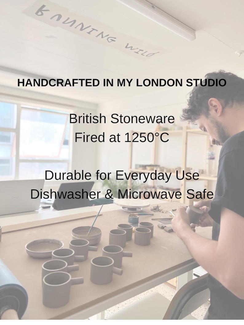 May include: A collection of handcrafted, gray stoneware mugs with handles, arranged on a wooden table. The text "HANDCRAFTED IN MY LONDON STUDIO" is visible. The mugs are durable for everyday use and are dishwasher and microwave safe.