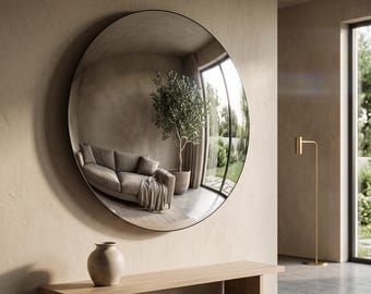 May include: A large, circular wall mirror with a thin black frame. The reflective surface shows a distorted view of a room containing a sofa, a potted plant, and a window. The mirror is mounted on a beige wall above a wooden bench with a vase.