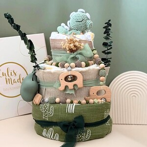 Windeltorte „Dino grün“ – Natur, Liebe & Lebensweisheit 🌿

Nachhaltiges Babygeschenk mit handgefertigter Symbolik

Willkommen, kleines Licht. 🤍
Diese liebevoll gestaltete Windeltorte ist mehr als nur ein Geschenk – sie trägt eine Botschaft fürs Leben.
Inspiriert von der grünen Dino, erinnert sie daran, dass Ruhe, Sanftheit und Liebe die größten Kräfte im Leben sind.