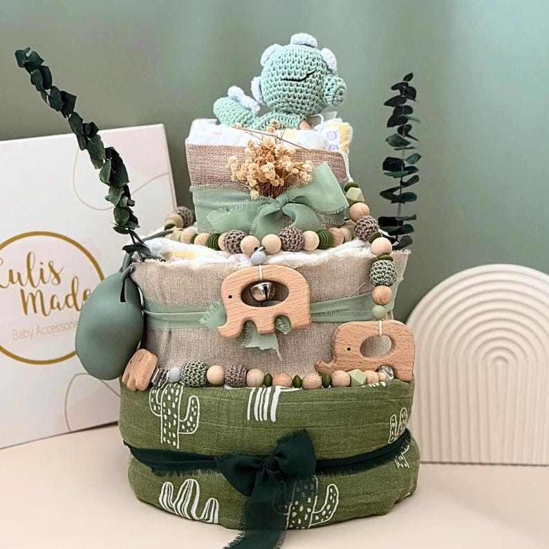 Windeltorte „Dino grün“ – Natur, Liebe & Lebensweisheit 🌿

Nachhaltiges Babygeschenk mit handgefertigter Symbolik

Willkommen, kleines Licht. 🤍
Diese liebevoll gestaltete Windeltorte ist mehr als nur ein Geschenk – sie trägt eine Botschaft fürs Leben.
Inspiriert von der grünen Dino, erinnert sie daran, dass Ruhe, Sanftheit und Liebe die größten Kräfte im Leben sind.