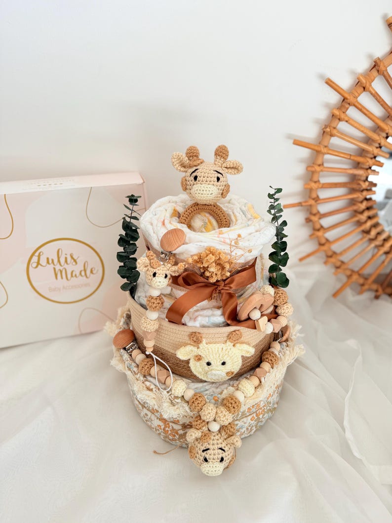 Dreistöckige Giraffen Windeltorte in Naturtönen mit Häkelapplikationen, Holzbeißring und Trockenblumen als personalisierbares Babygeschenk.