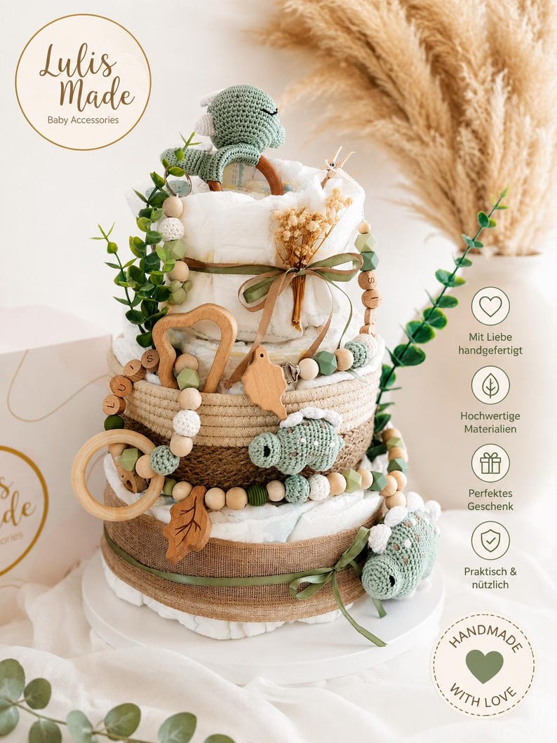 May include: A multi-tiered baby gift basket with a neutral color palette. The basket includes diapers, wooden toys, and crocheted dinosaur accents. The gift is decorated with greenery and a ribbon. The basket is handmade with love.