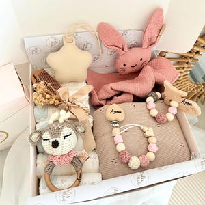 Diese handgefertigte süße Windelbox ist ein besonderes Highlight zur Geburt, Taufe oder Babyparty. Sie vereint praktische Babyartikel mit liebevollen Accessoires – nachhaltig, stilvoll und mit Herz gemacht.
Inhalt der Windeltorte:
• 🎀 8 Windeln (Pampers Premium Protection, Größe2
• 🧶 1 Babydecke aus gestrickter Baumwolle (weich & atmungsaktiv)
• 🧶 1 Babyspucktuch aus Bio Baumwolle 
• 🌿 1 Schnullerkette mit Holz-, Häkel- & Silikonperlen (CE-konform, personalisierbar mit Namen)