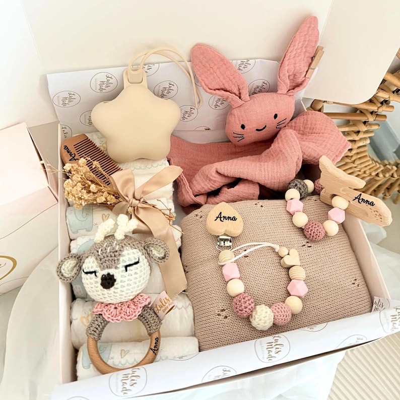 Diese handgefertigte süße Windelbox ist ein besonderes Highlight zur Geburt, Taufe oder Babyparty. Sie vereint praktische Babyartikel mit liebevollen Accessoires – nachhaltig, stilvoll und mit Herz gemacht.
Inhalt der Windeltorte:
• 🎀 8 Windeln (Pampers Premium Protection, Größe2
• 🧶 1 Babydecke aus gestrickter Baumwolle (weich & atmungsaktiv)
• 🧶 1 Babyspucktuch aus Bio Baumwolle 
• 🌿 1 Schnullerkette mit Holz-, Häkel- & Silikonperlen (CE-konform, personalisierbar mit Namen)