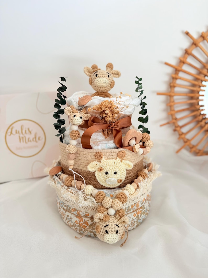 Boho Windeltorte mit Giraffen-Motiv in Beige und Braun, dekoriert mit Holzaccessoires und Schleife, liebevolles Geschenk zur Geburt.
