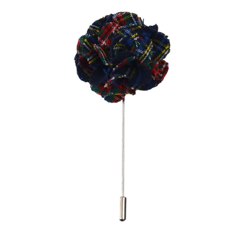 May include: A fabric lapel flower with a plaid pattern in navy, red, green, and yellow. The flower is attached to a silver-colored pin with a small, cylindrical cap at the end. The accessory is set against a white background.