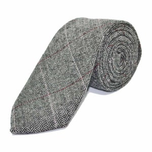 May include: A gray and white herringbone patterned tie with a thin red stripe. The tie is rolled up and ready to be worn.
