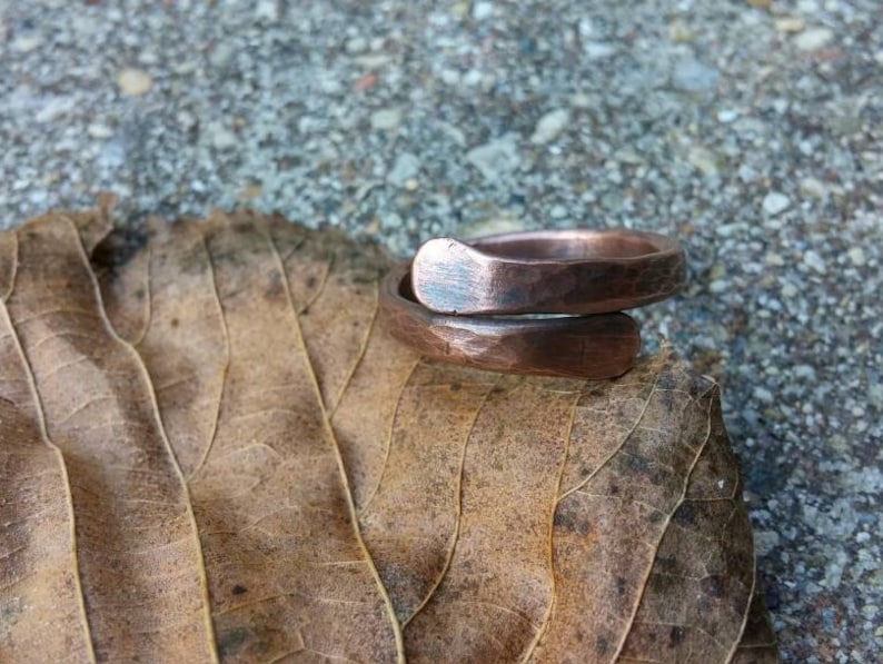 Pu&ograve; includere: Un anello in rame con finitura martellata. L'anello &egrave; aperto e ha un design semplice.