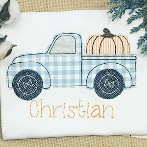 May include: A blue and white gingham truck with a pumpkin in the bed. The truck has black wheels and the name "Christian" is embroidered below the truck.
