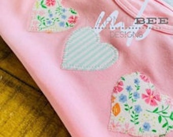 May include: Pink sleeveless shirt with three appliqued hearts. The hearts are in a floral print, a striped print, and a floral print. The shirt has the text "Made by Design" on the front.