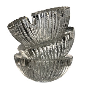 May include: Three clear glass bowls stacked on top of each other. The bowls have a textured, ribbed design.