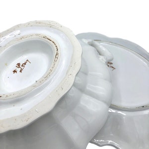 May include: White ceramic serving dish with a scalloped edge. The bottom of the dish has the text "*  mi.Italy" in brown lettering.