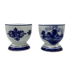 Vintage pair of Delft Blue and White porcelain Egg Cups hand-painted pieces in excellent condition. Delft Decor. Light blue background.