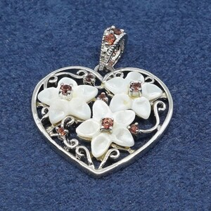 Colgante vintage hecho a mano en plata de ley 925, corazón con flor de nácar y rubí.