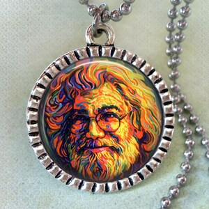 May include: A silver chain necklace with a round pendant featuring a colorful portrait of Jerry Garcia. The pendant has a silver rim with a decorative edge.