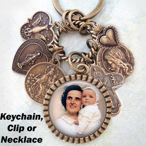 May include: A bronze charm necklace featuring a photo of a woman and a child. The charm necklace also includes a heart, a cross, and a religious medal. The necklace is available as a keychain, clip, or necklace.