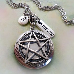 May include: Silver necklace with a pentacle locket, a charm that says "PROTECTED", and a charm with the letter "M".