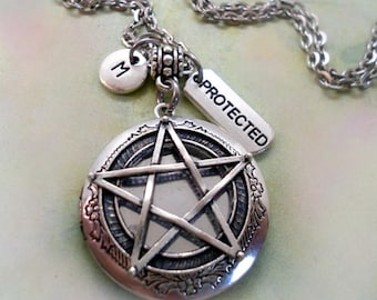 Puede incluir: Collar de plata con un dije de pentáculo, un dije que dice "PROTECTED" y un dije con la letra "M".