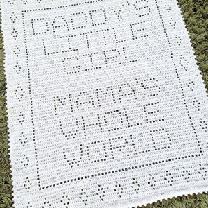 K&ouml;nnte beinhalten: Wei&szlig;e geh&auml;kelte Babydecke mit einem zarten Muster aus Blumen und Bl&auml;ttern. Die Decke hat einen gewellten Rand.