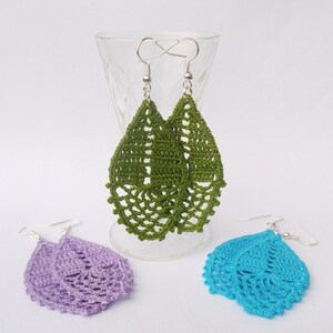 May include: Three pairs of crocheted earrings in green, purple, and blue. The earrings are teardrop shaped and have a delicate, lacy design.