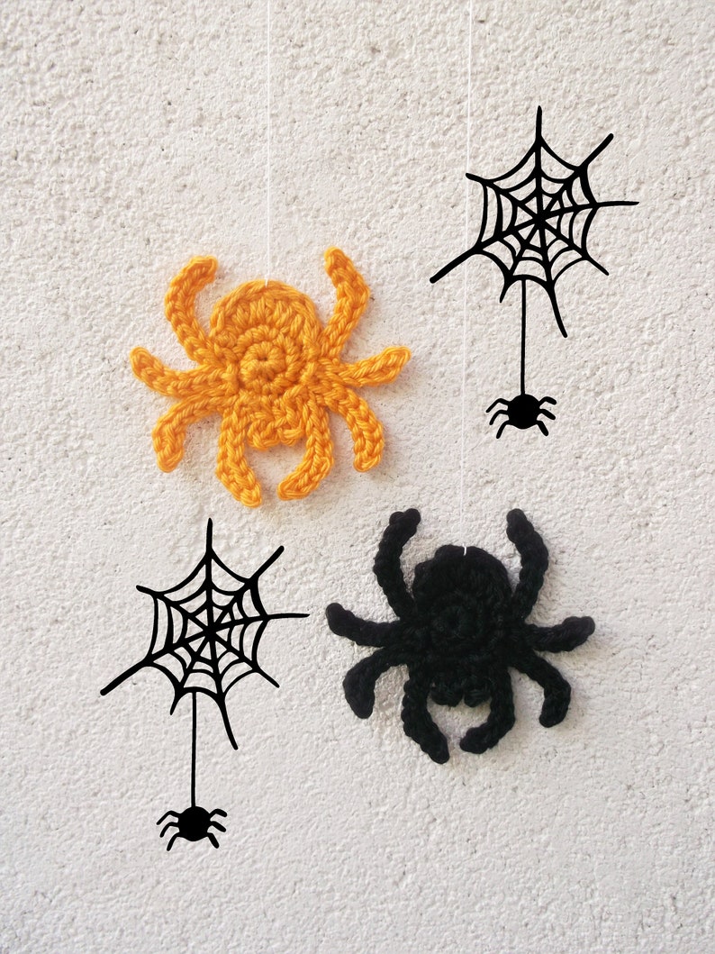 May include: Four Halloween decorations hanging from strings against a white wall. Two black crocheted spiders and two black web designs with a small black spider at the bottom. One spider is orange.