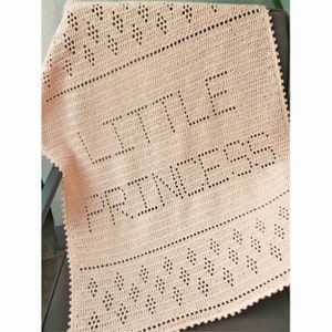 May include: A pale pink crocheted baby blanket with the words "Little Princess" in a larger stitch.
