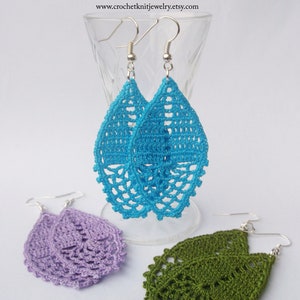 May include: Three pairs of crocheted teardrop-shaped earrings in turquoise, lavender, and olive green. The earrings are handmade and feature a delicate, lacy design.