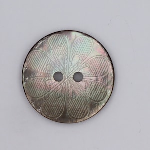 May include: A two-hole iridescent mother of pearl button with a floral design.