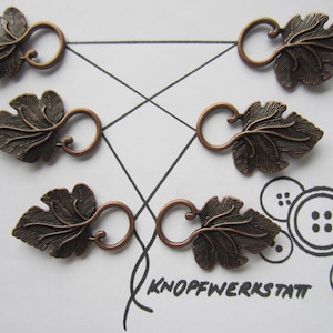 May include: Five antique copper-toned leaf-shaped toggles with a loop for threading. Each toggle features a detailed leaf design with a textured surface.