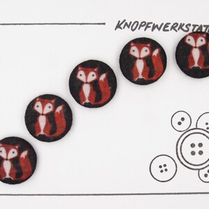 May include: Five black buttons with a red fox design. The buttons are arranged in a row on a white background. The text "KNO PFWERKSTATT" is printed in black at the top of the image.