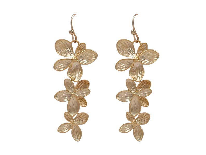 May include: A pair of gold-colored floral drop earrings. Each earring features three flower-shaped pendants, with detailed petal textures. The earrings hang from a simple hook design, suitable for pierced ears. The background is plain white.