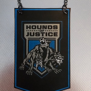Könnte beinhalten: Ein schwarzes und blaues Banner mit einer Kette, die oben hängt. Das Banner trägt den Text "HOUNDS OF JUSTICE" und eine Grafik eines dreiköpfigen Hundes.