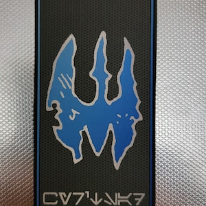 May include: A black and blue patch with a stylized blue symbol and the text "CV7'1^NK7".