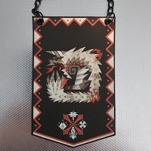 Könnte beinhalten: Schwarz-weißes Banner mit einem weißen Monster mit roten Akzenten. Das Banner hat einen roten und weißen Rand mit einem schwarz-weißen Muster. Das Banner hat eine Kette, die oben befestigt ist.