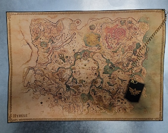 Puede incluir: Un mapa de estilo vintage de Hyrule, la tierra ficticia de la serie de videojuegos The Legend of Zelda. El mapa está impreso en papel similar al pergamino y presenta una representación detallada del paisaje de Hyrule, incluyendo montañas, bosques y ríos. El mapa está enmarcado con un borde decorativo e incluye un pequeño emblema triangular negro con un diseño estilizado.
