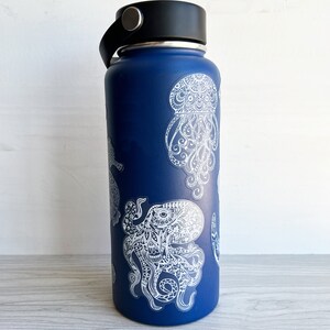 May include: A blue reusable water bottle featuring white octopus and jellyfish designs. The designs are intricate and detailed, resembling a mandala.