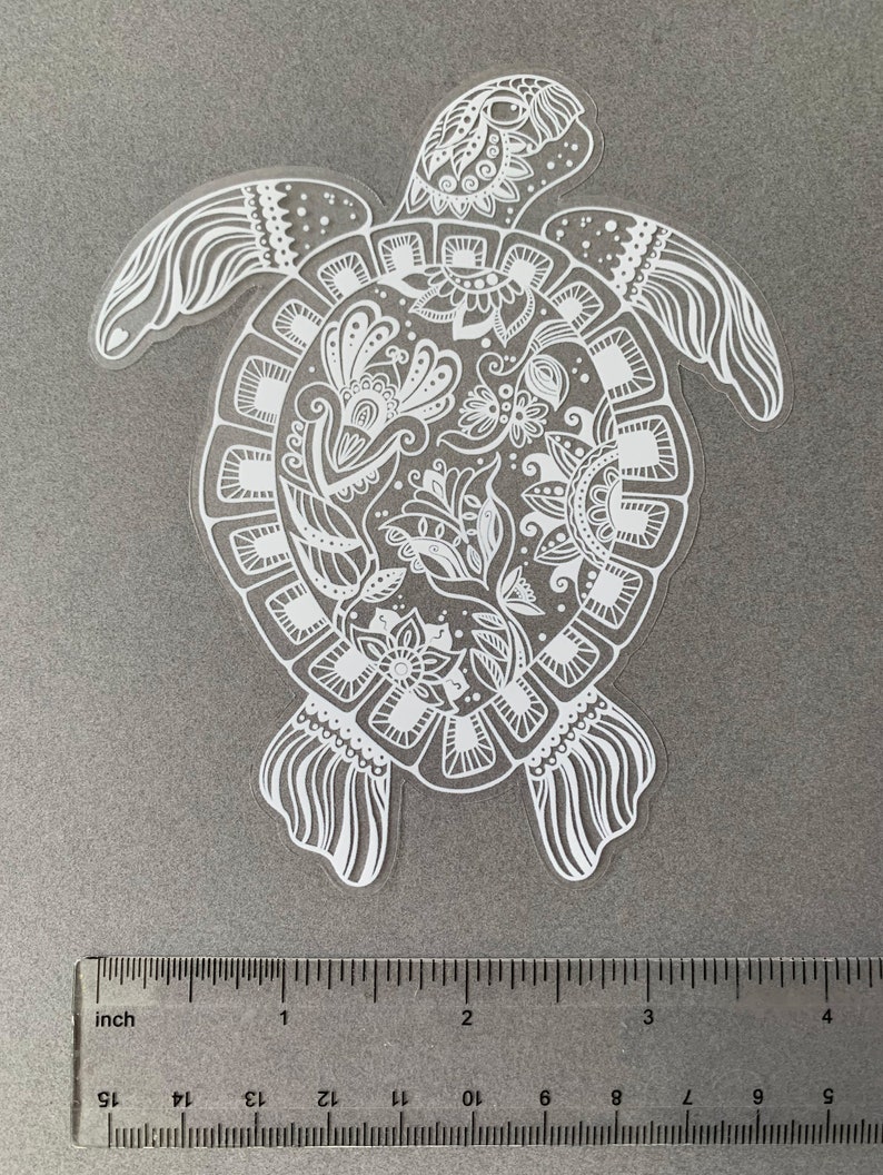 May include: White vinyl sticker of a detailed turtle with a floral mandala design. The turtle is approximately 3 inches wide.