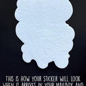 May include: White sticker featuring a detailed, intricate design of a stylised octopus with flowing tentacles. The sticker is on a black background.