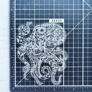 May include: A white vinyl sticker of an intricate, detailed octopus with a mandala-like design. The sticker is 2.5 inches by 3.5 inches.