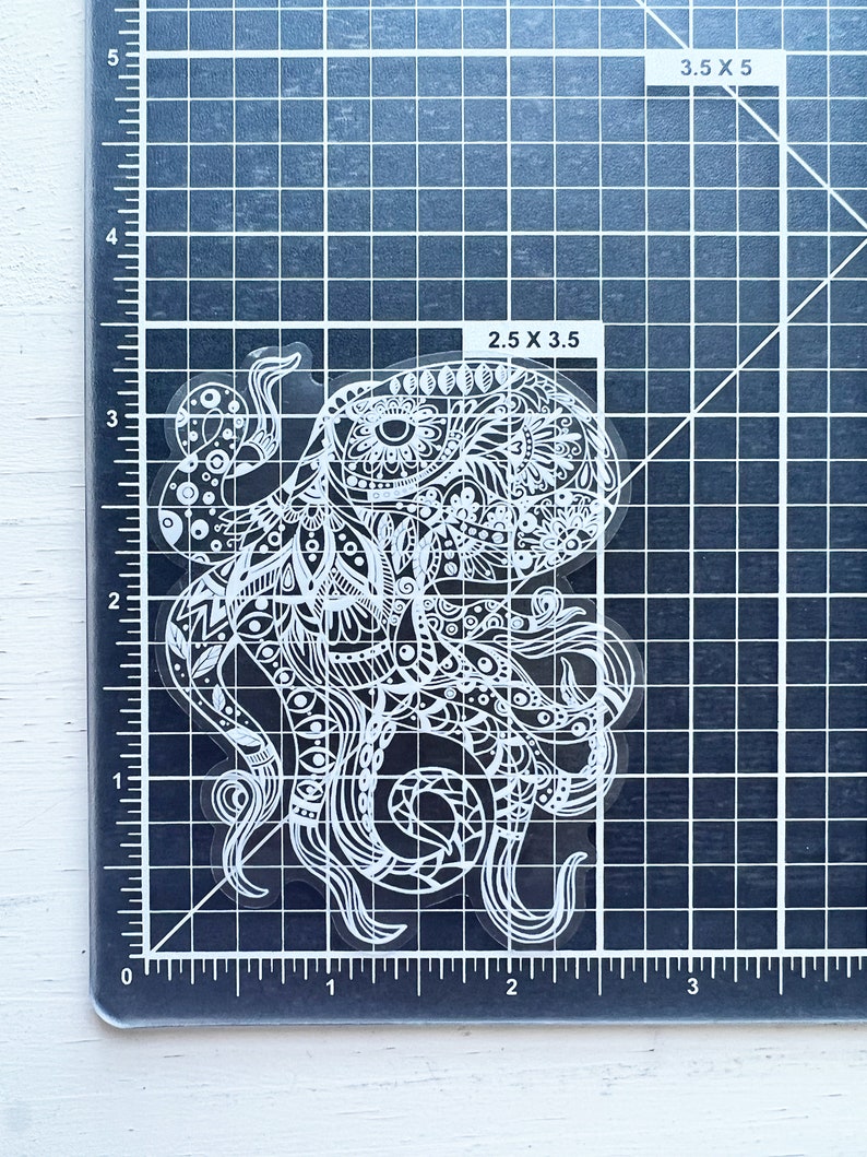 May include: A white vinyl sticker of an intricate, detailed octopus with a mandala-like design. The sticker is 2.5 inches by 3.5 inches.