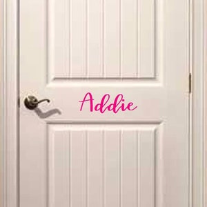 May include: White interior door with a pink vinyl decal that says "Addie" on it.