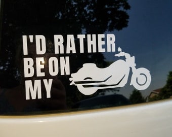 May include: A white vinyl sticker with the text "I'd rather be on my" and a silhouette of a motorcycle.